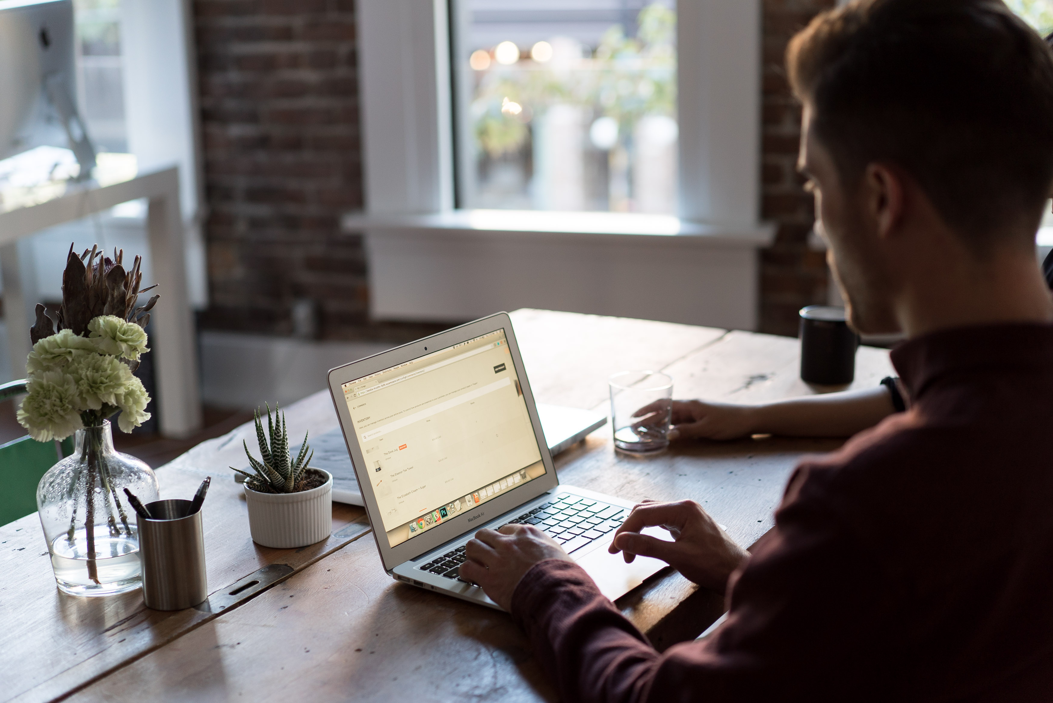 A professional working on a laptop in a bright office